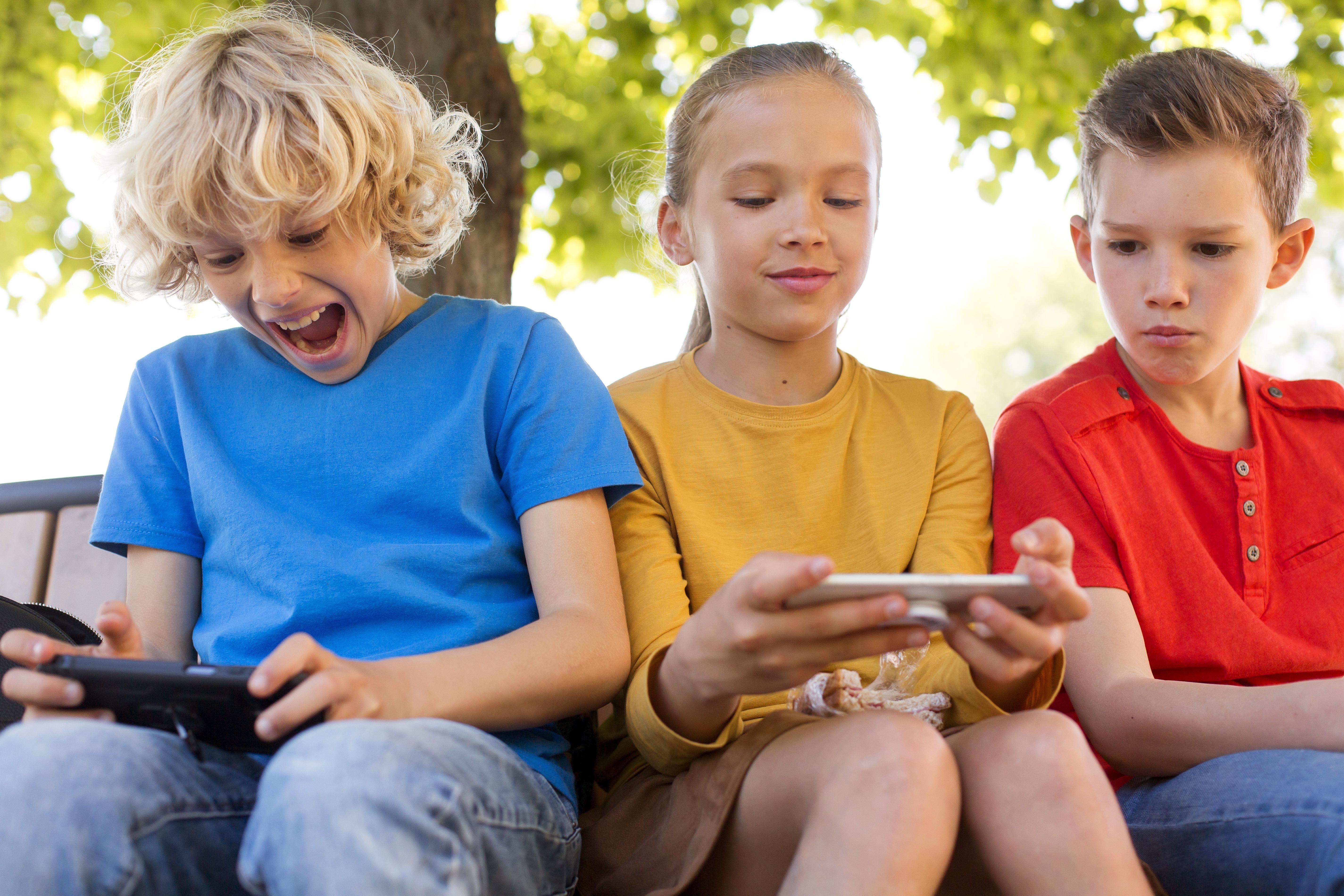 Kursfoto Drei Kinder sitzen auf einer Bank